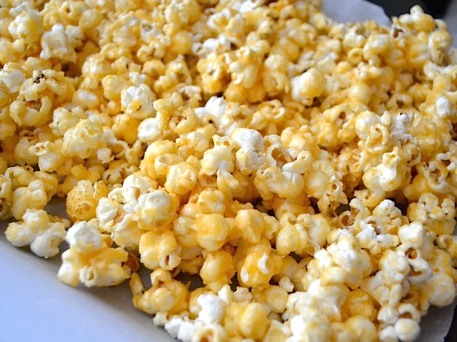 maïs cuit étalé sur une plaque à pâtisserie tapissée de papier parchemin et recouvert de sauce au sucre 