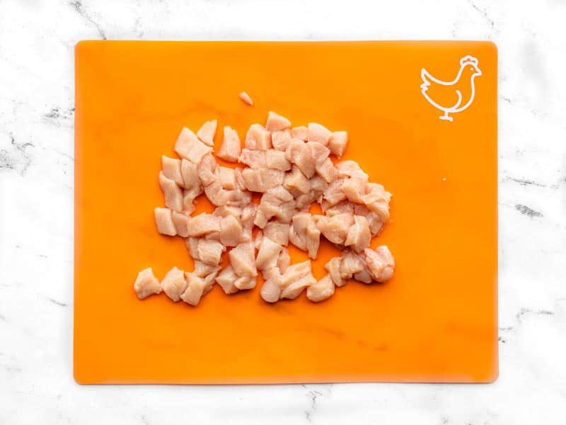 Poitrine de poulet hachée sur une planche à découper orange