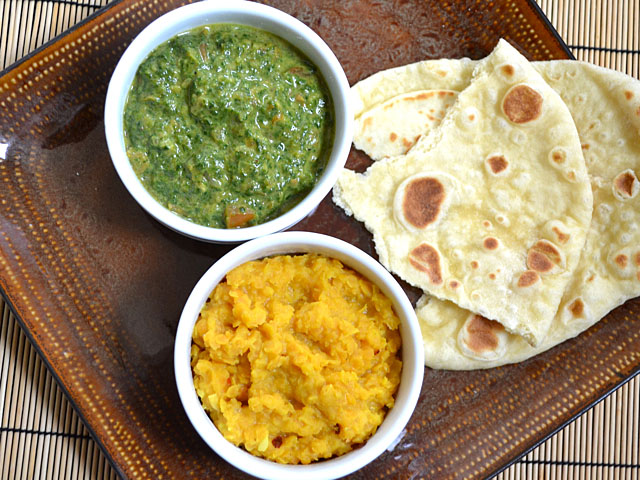 bol de lentilles à la noix de coco et bol d'épinards à la crème avec naan sur le côté