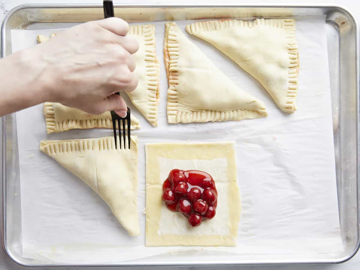 Les coutures de la pâte feuilletée sont scellées à la fourchette.
