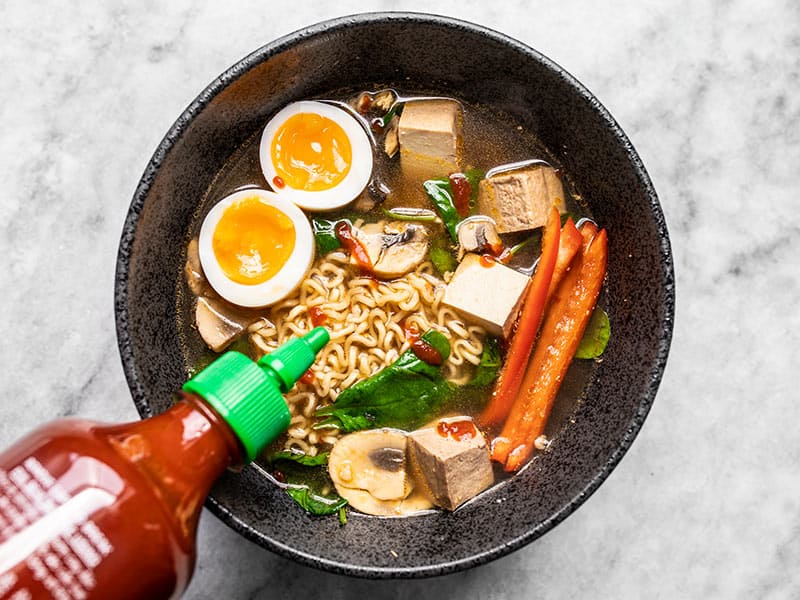 Sriracha arrosée sur un bol de Ramen instantané amélioré.