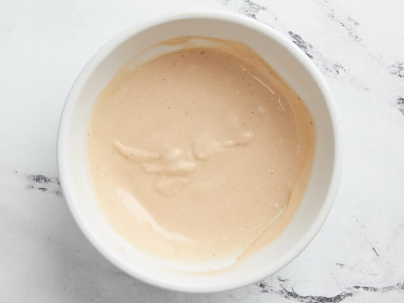 Coup de sauce dans un petit bol blanc.
