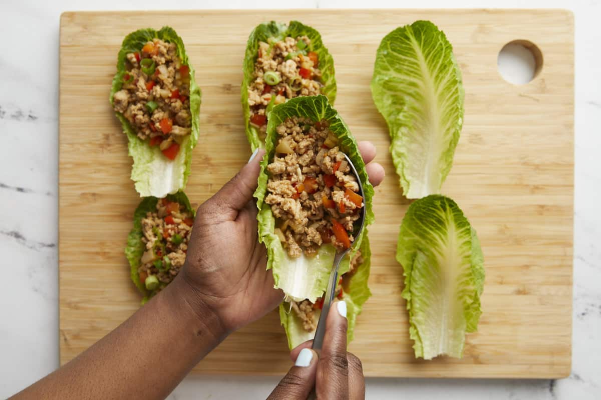 Garniture de poulet et de légumes ajoutée aux wraps de laitue au poulet.