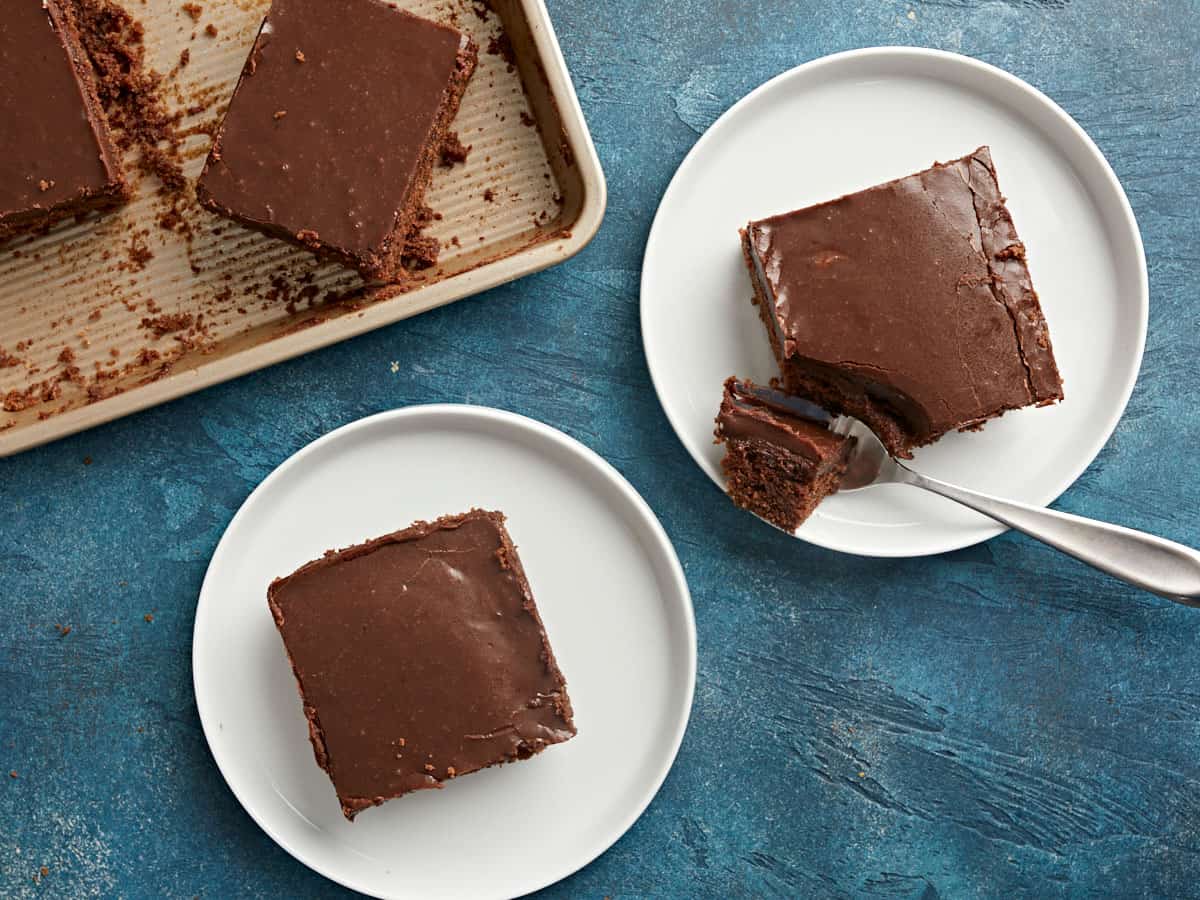 Deux assiettes avec des tranches de gâteau dessus, une avec une fourchette. 