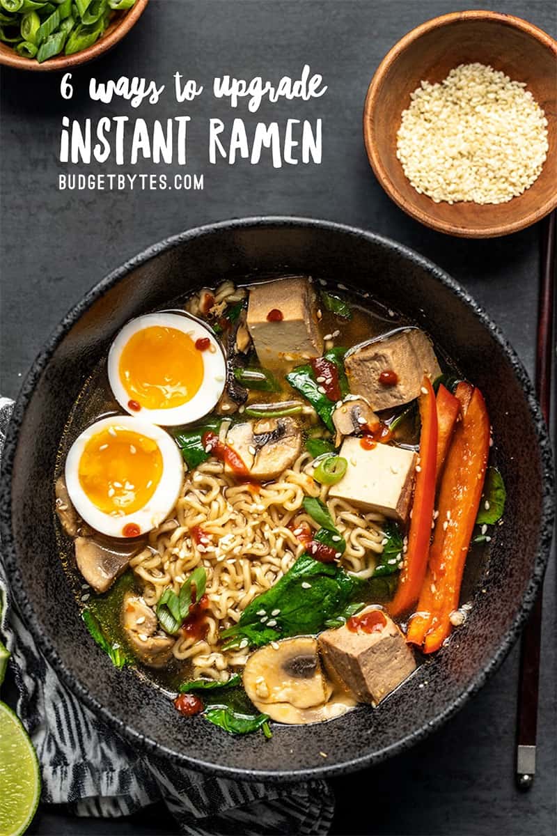 Un bol de ramen instantané amélioré avec des légumes, un œuf à la coque et de la sriracha.  Citrons verts sur le côté.