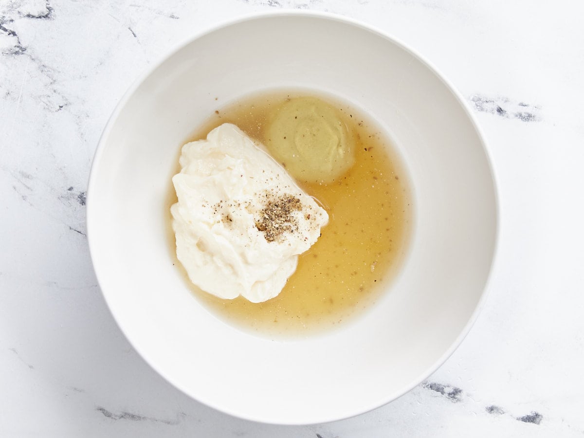 Ingrédients pour la vinaigrette dans un bol, non mélangés.