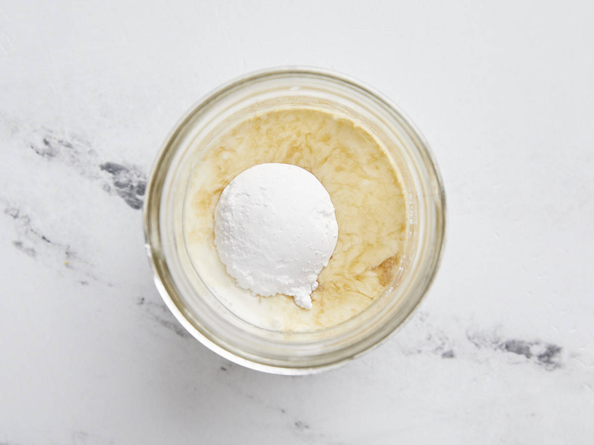 Lait, crème, sucre et vanille dans un pot.