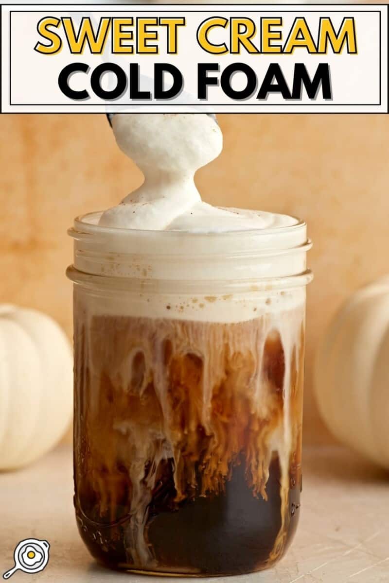 Mousse froide à la crème sucrée sur un pot Mason rempli de café glacé.