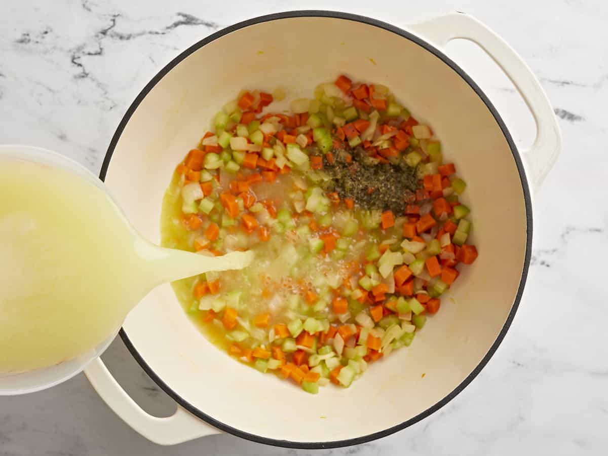 Légumes cuits dans la marmite avec assaisonnement italien et bouillon de poulet versé.