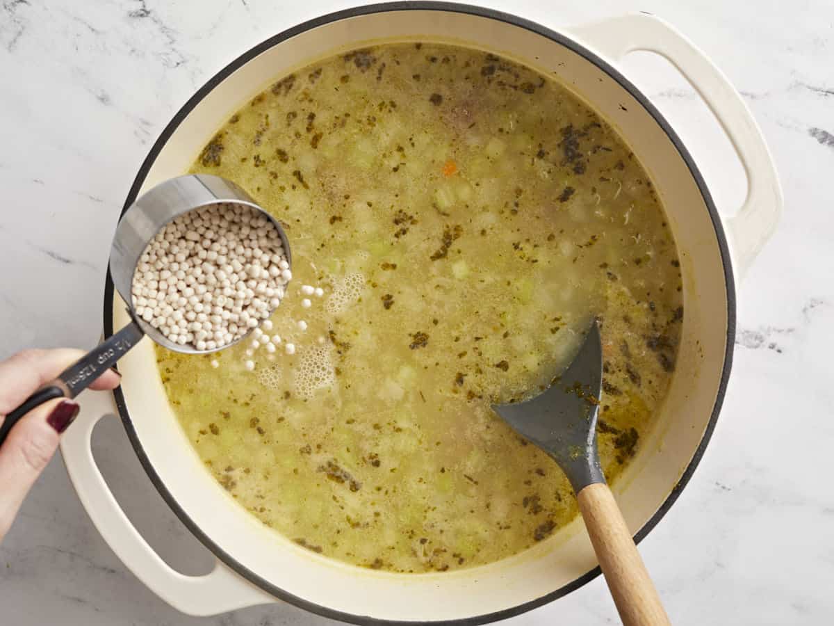 Pâtes étant ajoutées à la soupe. 