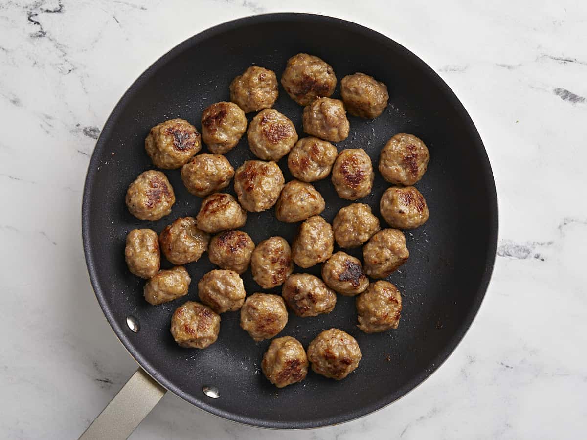 Boulettes de viande dorées dans une poêle.