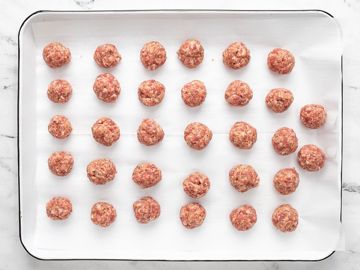 Façonner des boulettes de viande sur une plaque à pâtisserie recouverte de papier sulfurisé. 