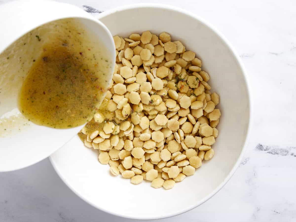 Mélange de beurre fondu versé sur des craquelins aux huîtres dans un bol.