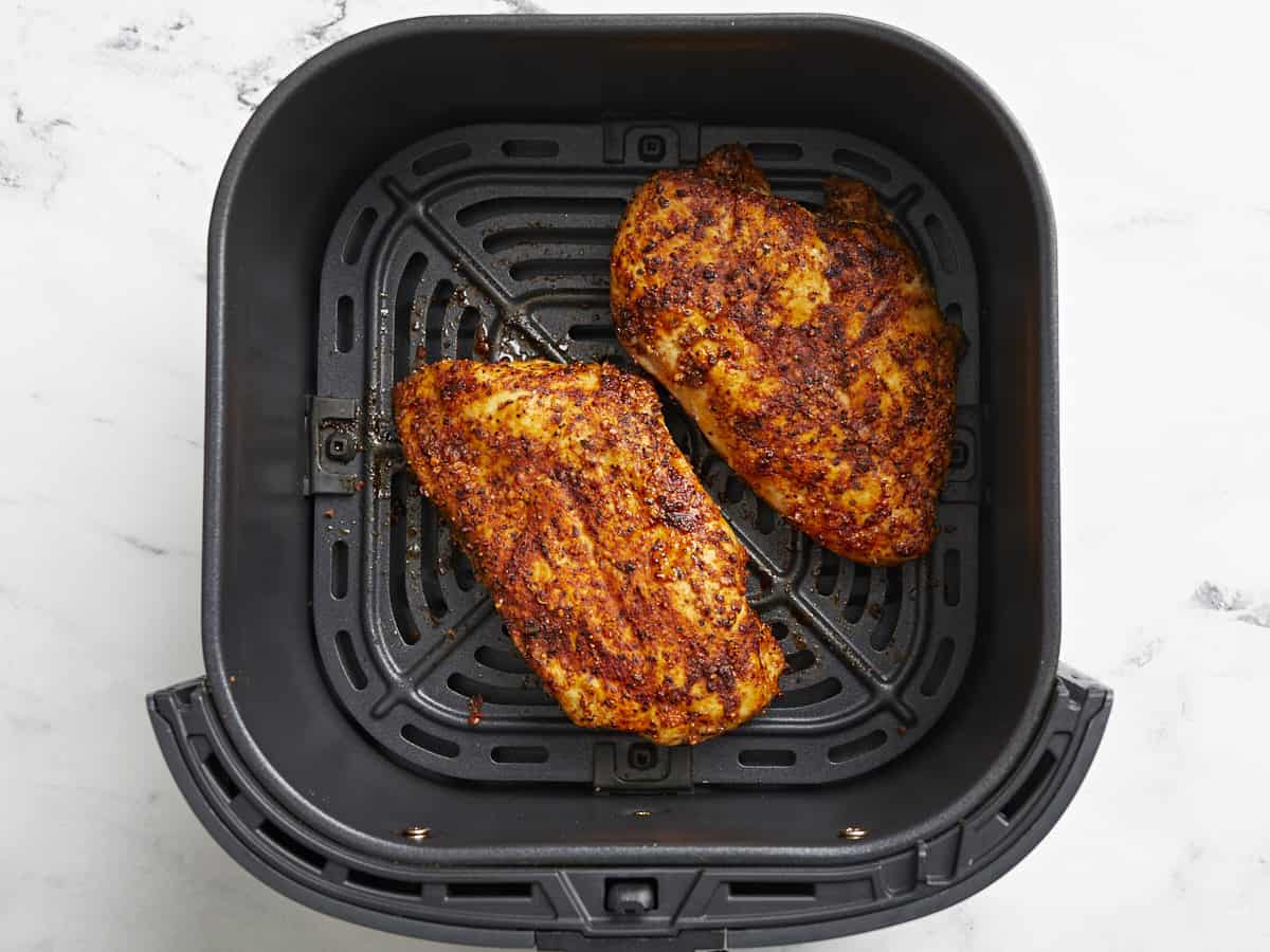 Poitrines de poulet cuites dans un panier de friteuse à air.