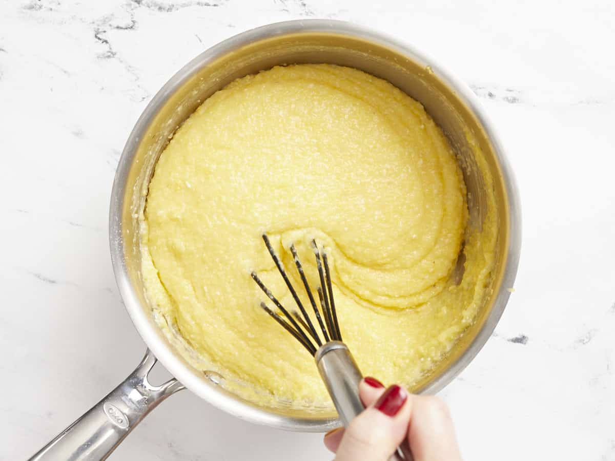 Polenta crémeuse finie agitée avec un fouet.