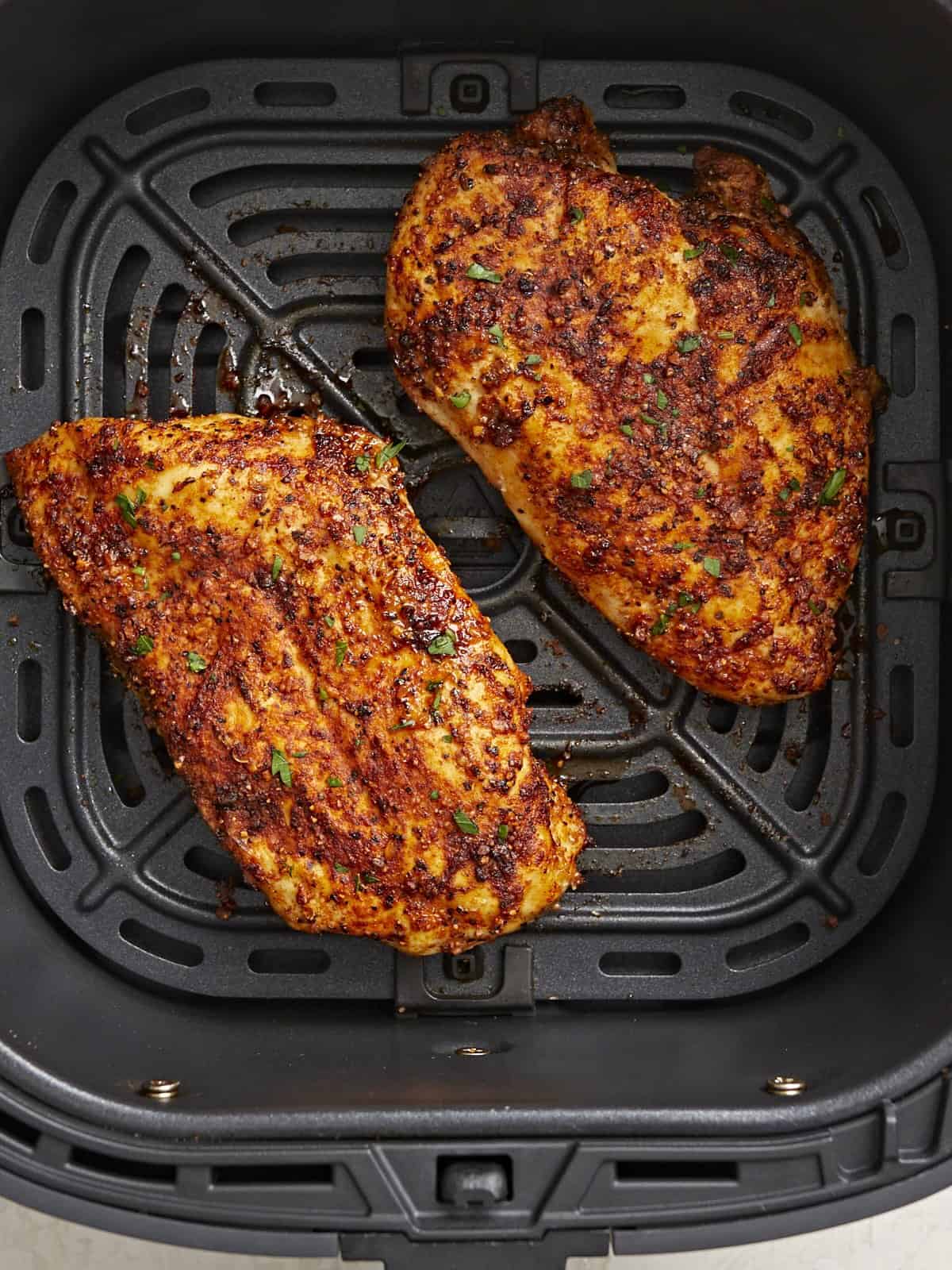 Vue aérienne cuite des poitrines de poulet de la friteuse à air dans un panier de friteuse à air.