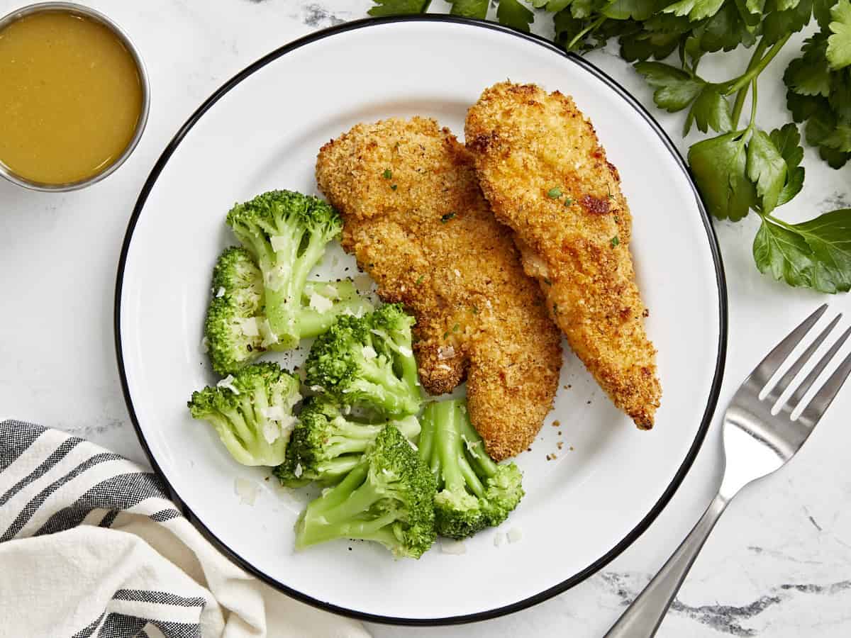 Vue aérienne des filets de poulet de la friteuse à air et du brocoli cuit à la vapeur sur une assiette.