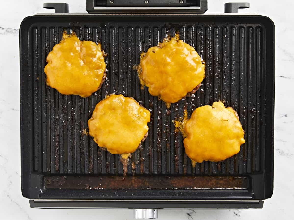 Hamburgers avec du fromage fondu sur le gril.