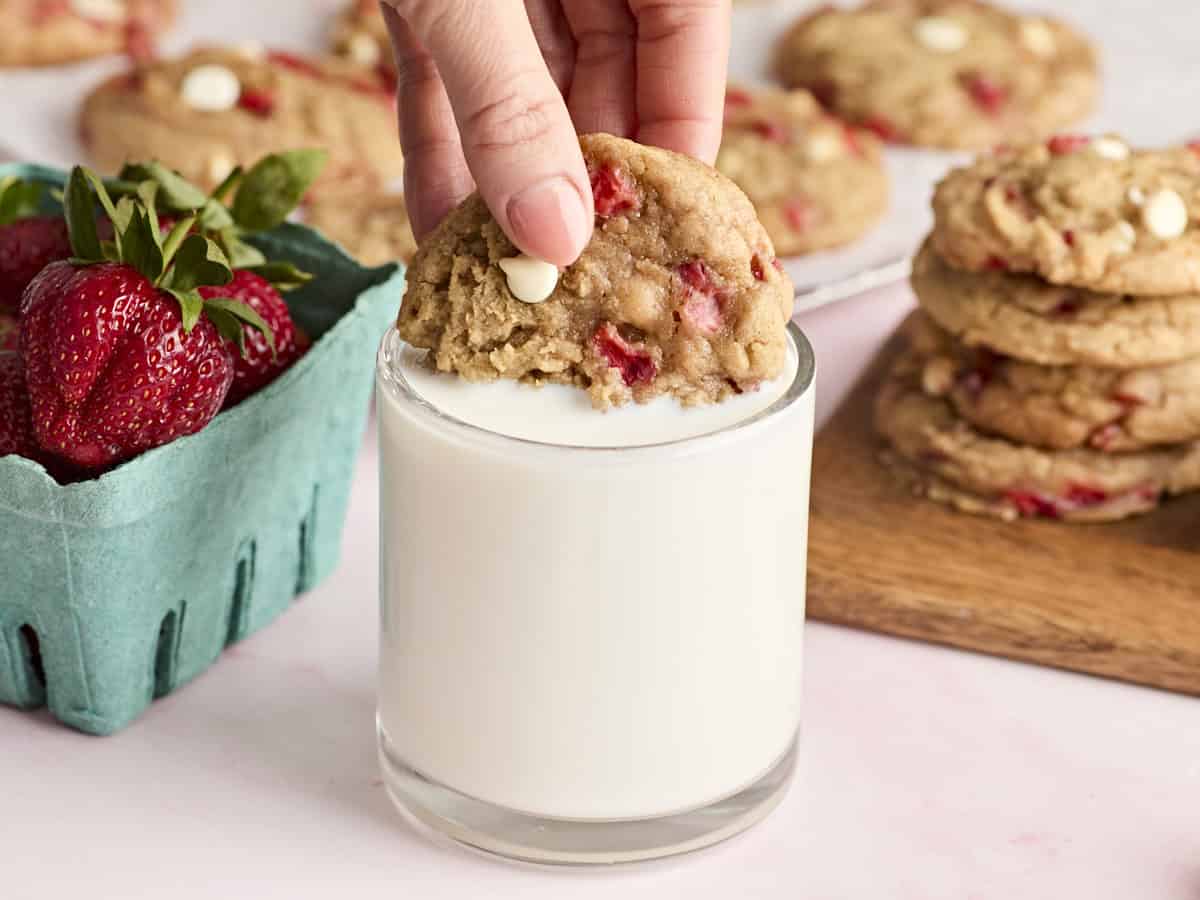tremper un biscuit aux fraises dans un verre de lait.
