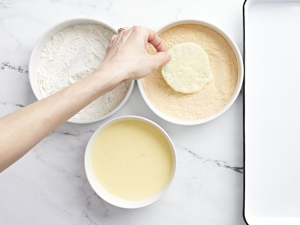 tremper une tomate verte dans de la farine assaisonnée et de la semoule de maïs.