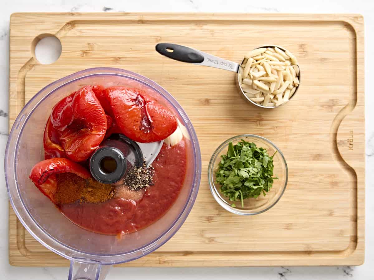 Ingrédients pour la sauce romesco dans un robot culinaire