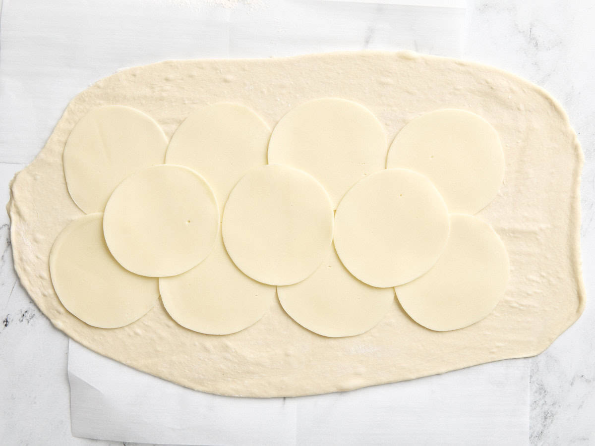 Pâte à pizza garnie de tranches de fromage