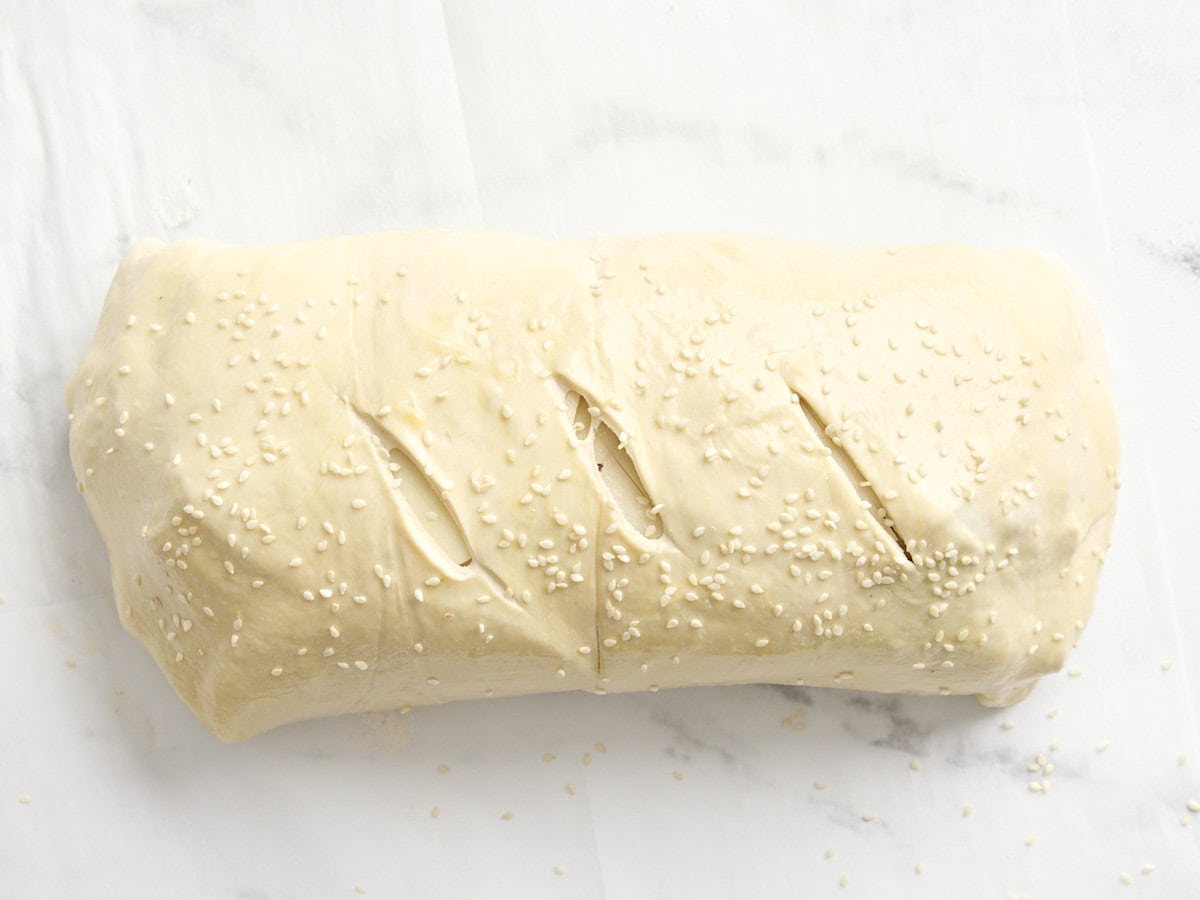 Rouleau de muffaletta non cuit garni de graines de sésame