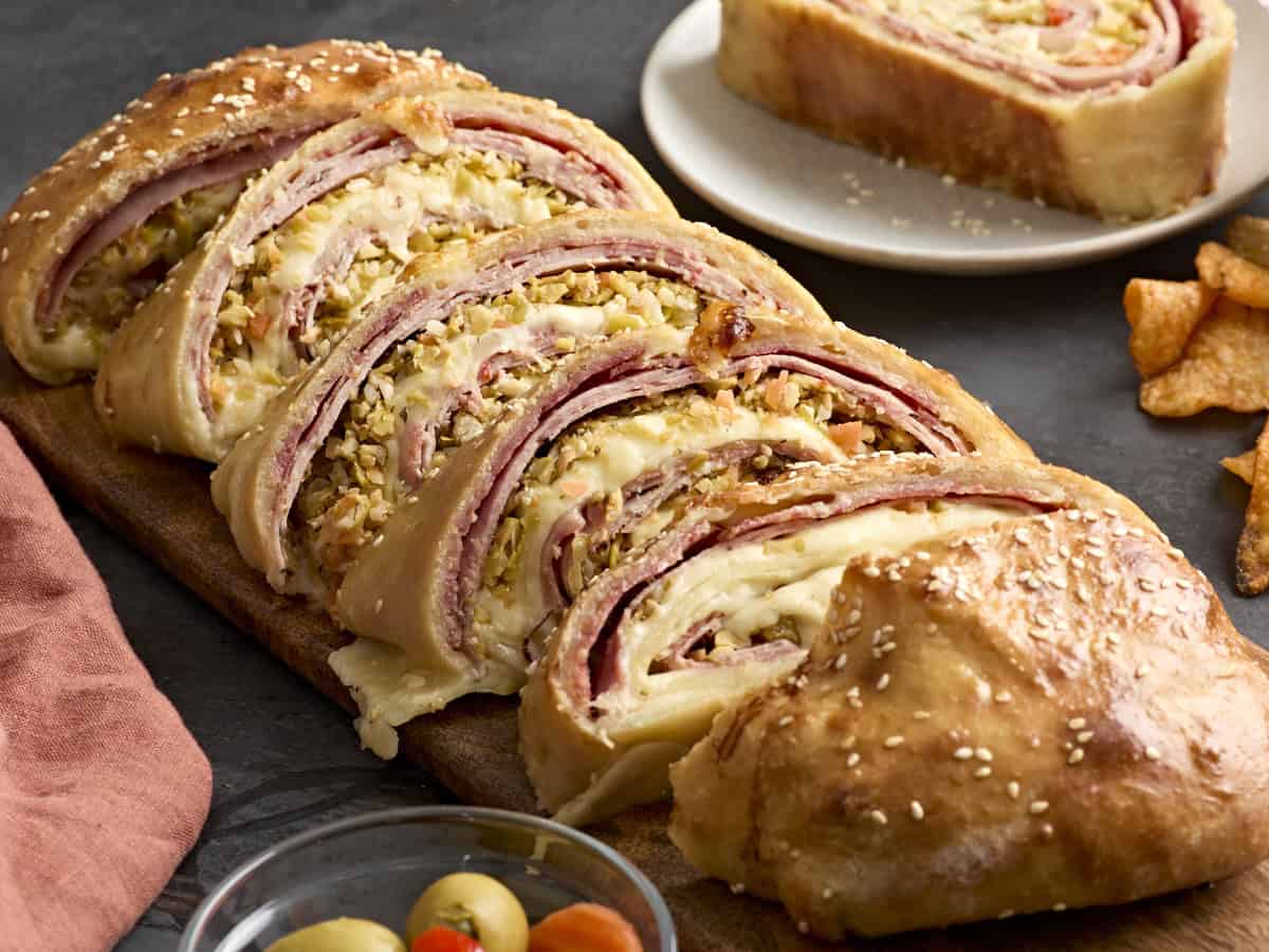 Rouleaux de muffaletta sur une planche à découper en bois