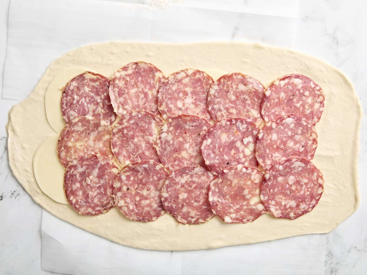 Pâte à pizza garnie de tranches de salami