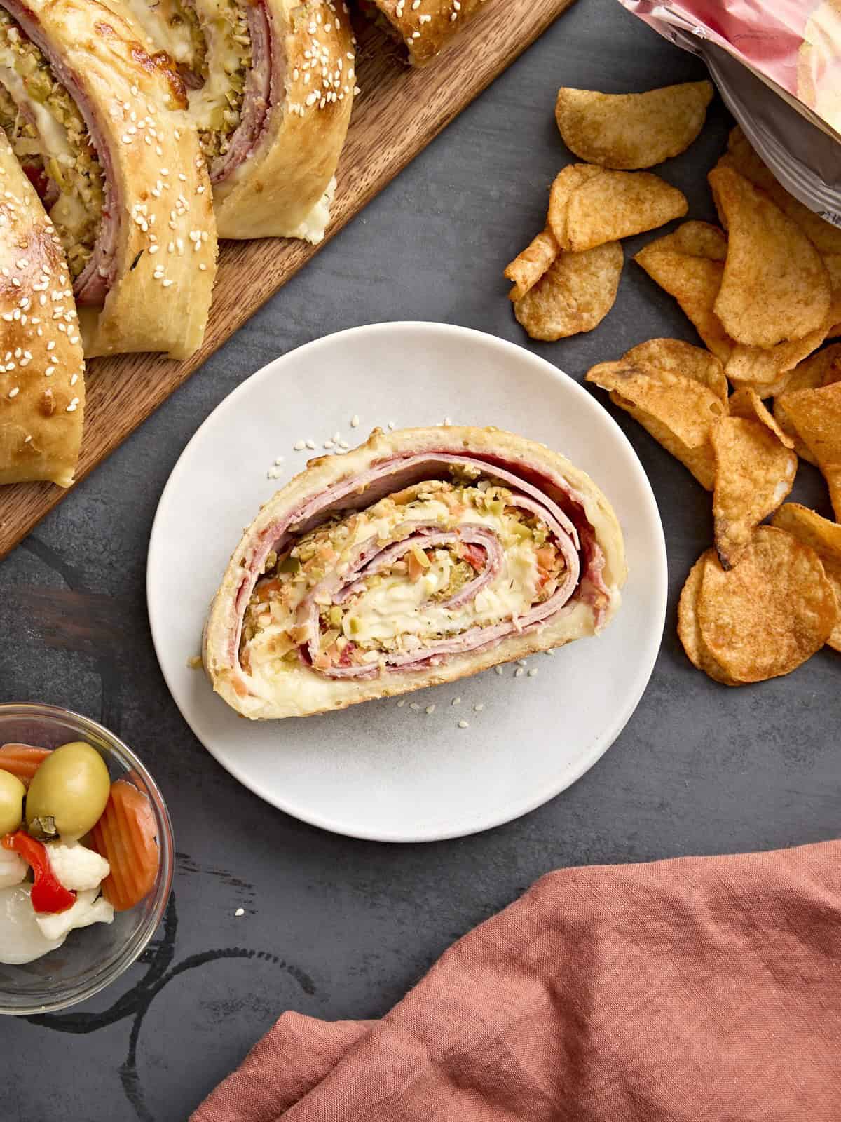 Une tranche de muffaletta roulée sur une assiette