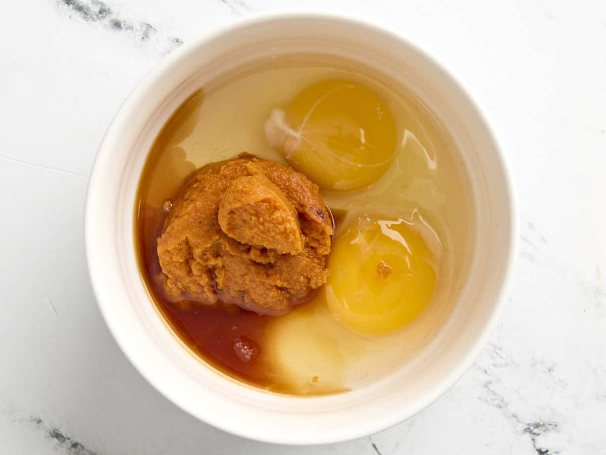 Purée de citrouille, œufs et vanille dans un bol à mélanger.