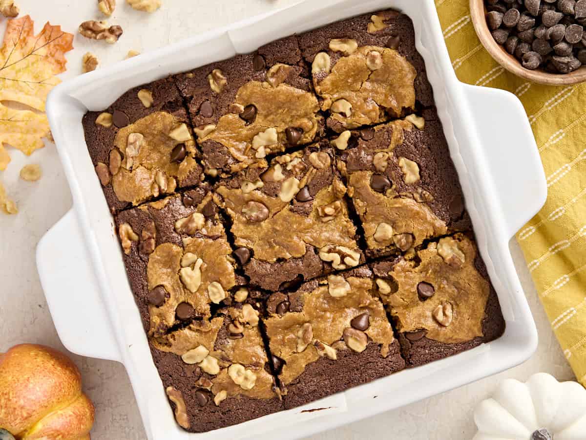 Vue aérienne de brownies à la citrouille dans un plat allant au four recouvert de papier sulfurisé.