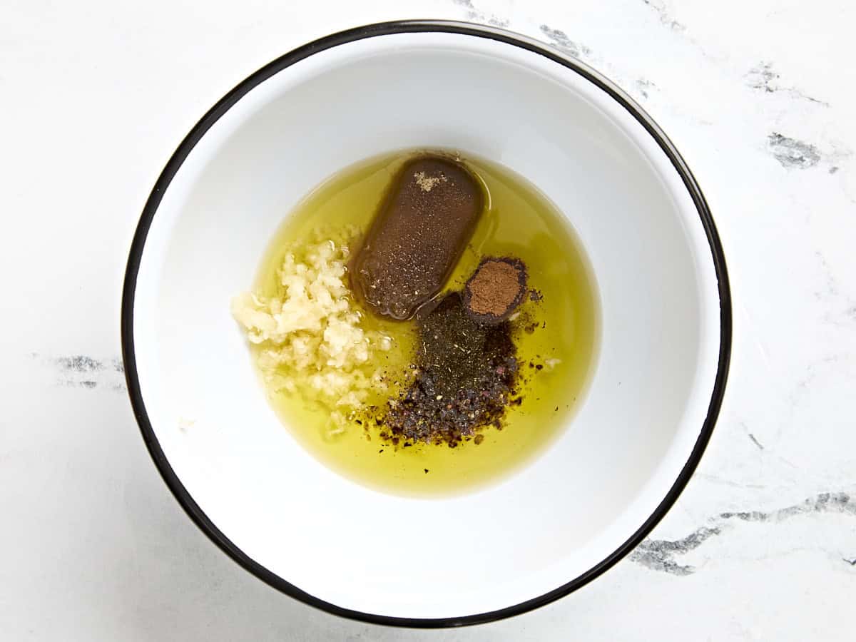 Sucre, huile, ail émincé et assaisonnements dans un bol à mélanger.