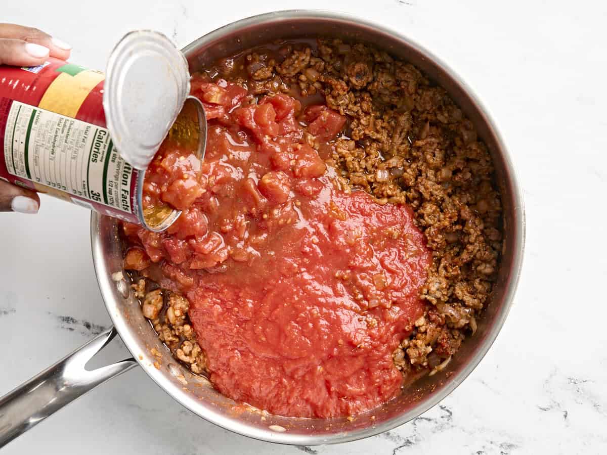 Tomates en conserve ajoutées à la poêle.
