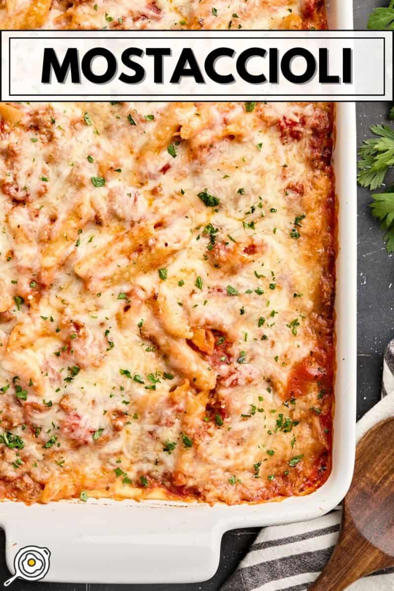 Vue aérienne des mostaccioli cuits au four dans un plat de cuisson blanc avec le texte du titre en haut.
