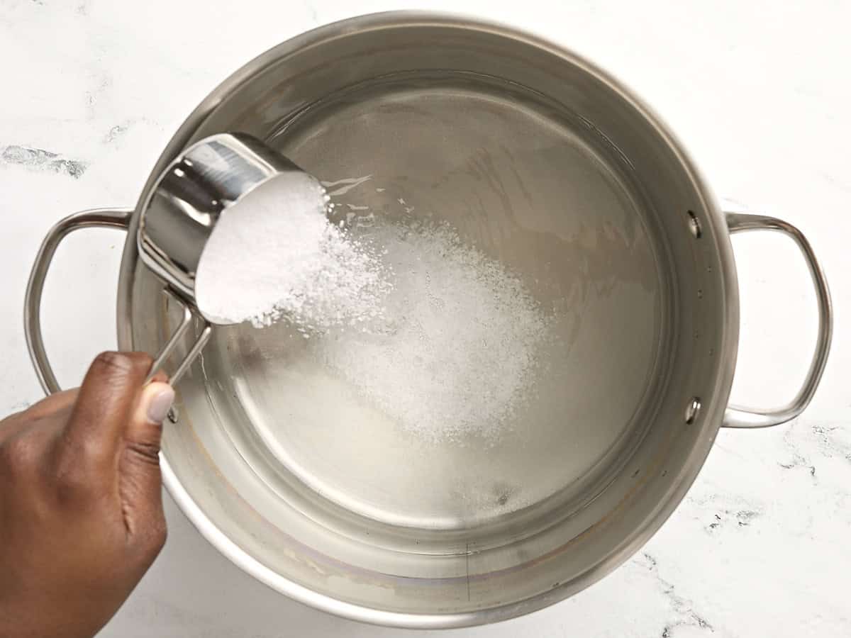 Sel et sucre ajoutés à une grande casserole d'eau.
