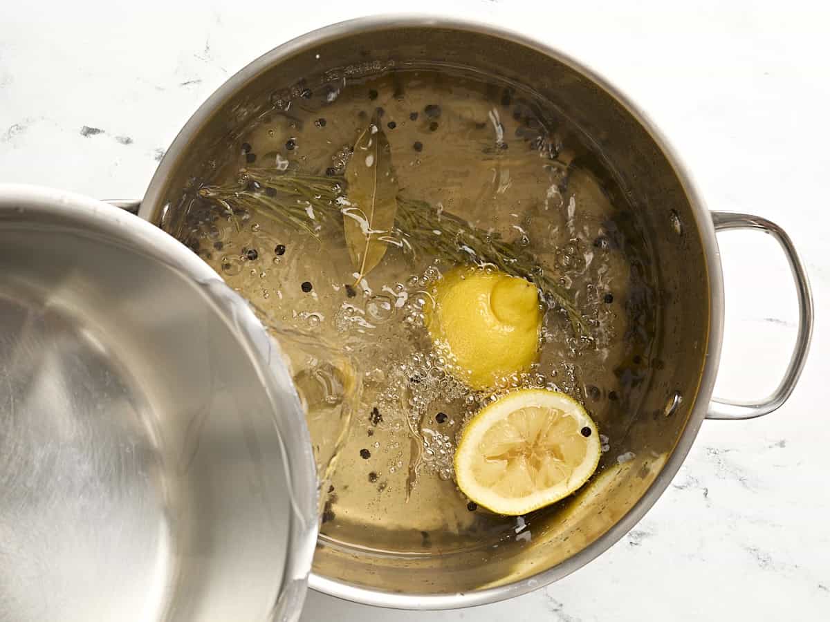 De l'eau froide est ajoutée à une grande casserole d'eau.