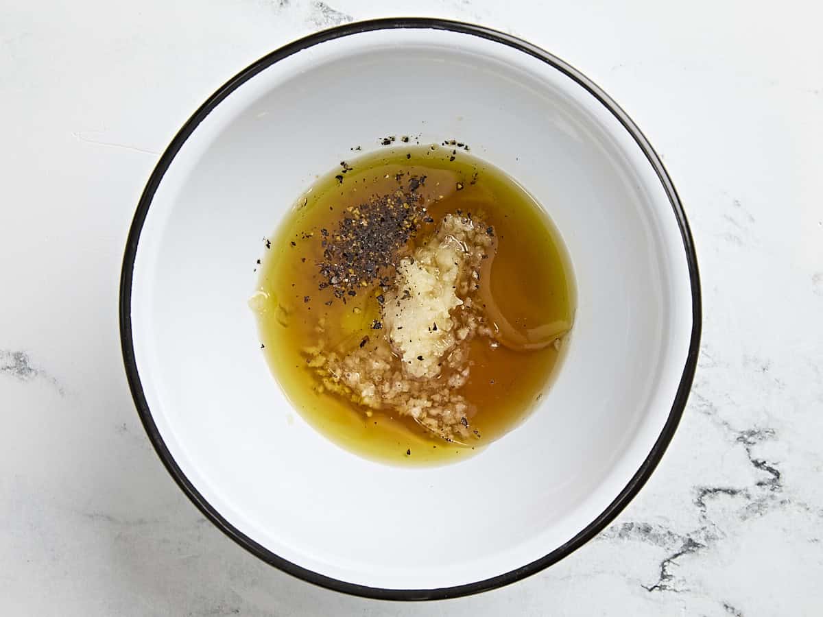 Huile, sirop d'érable, ail et assaisonnements dans un bol.