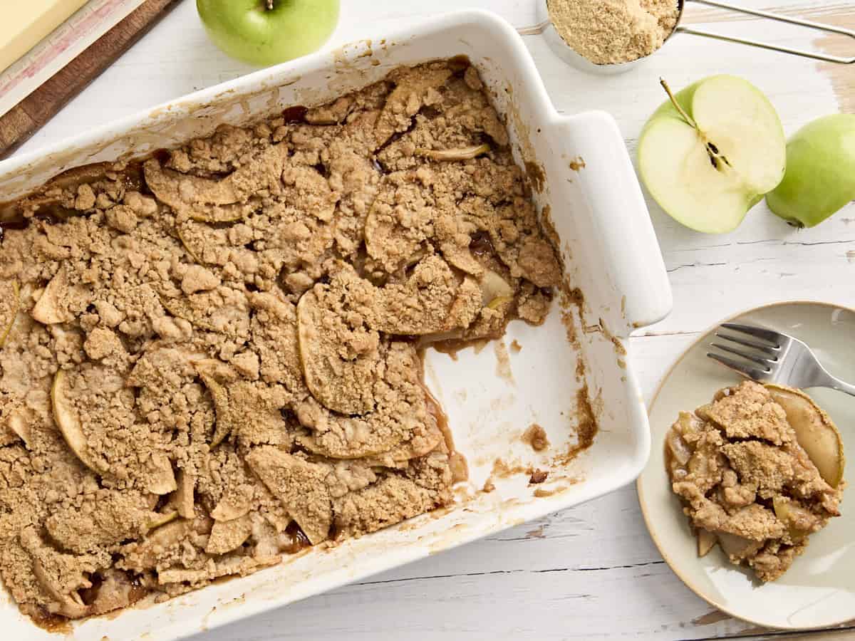 Vue aérienne du crumble aux pommes dans un plat rectangulaire avec une partie manquante.
