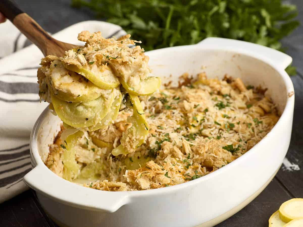 Vue latérale de la cocotte de courge extraite d'une cocotte avec une cuillère en bois.