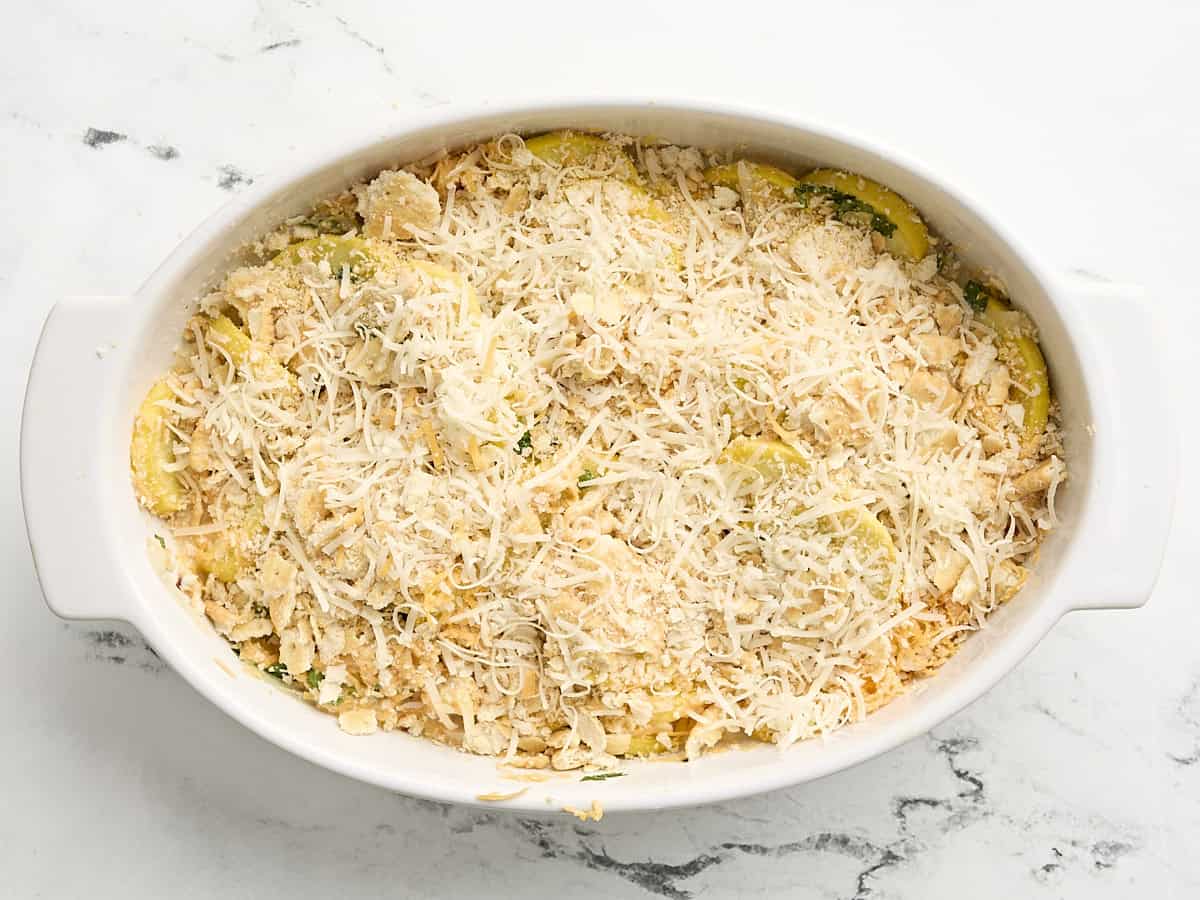 Casserole de courge garnie de fromage râpé dans une cocotte.