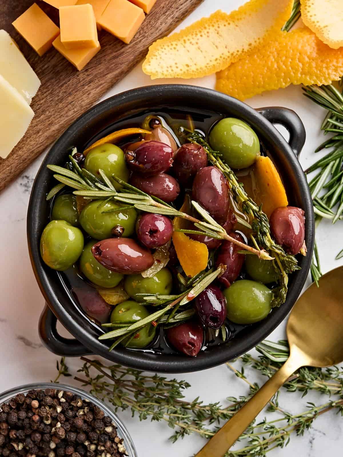 Vue aérienne d'un bol d'olives marinées aux herbes fraîches.