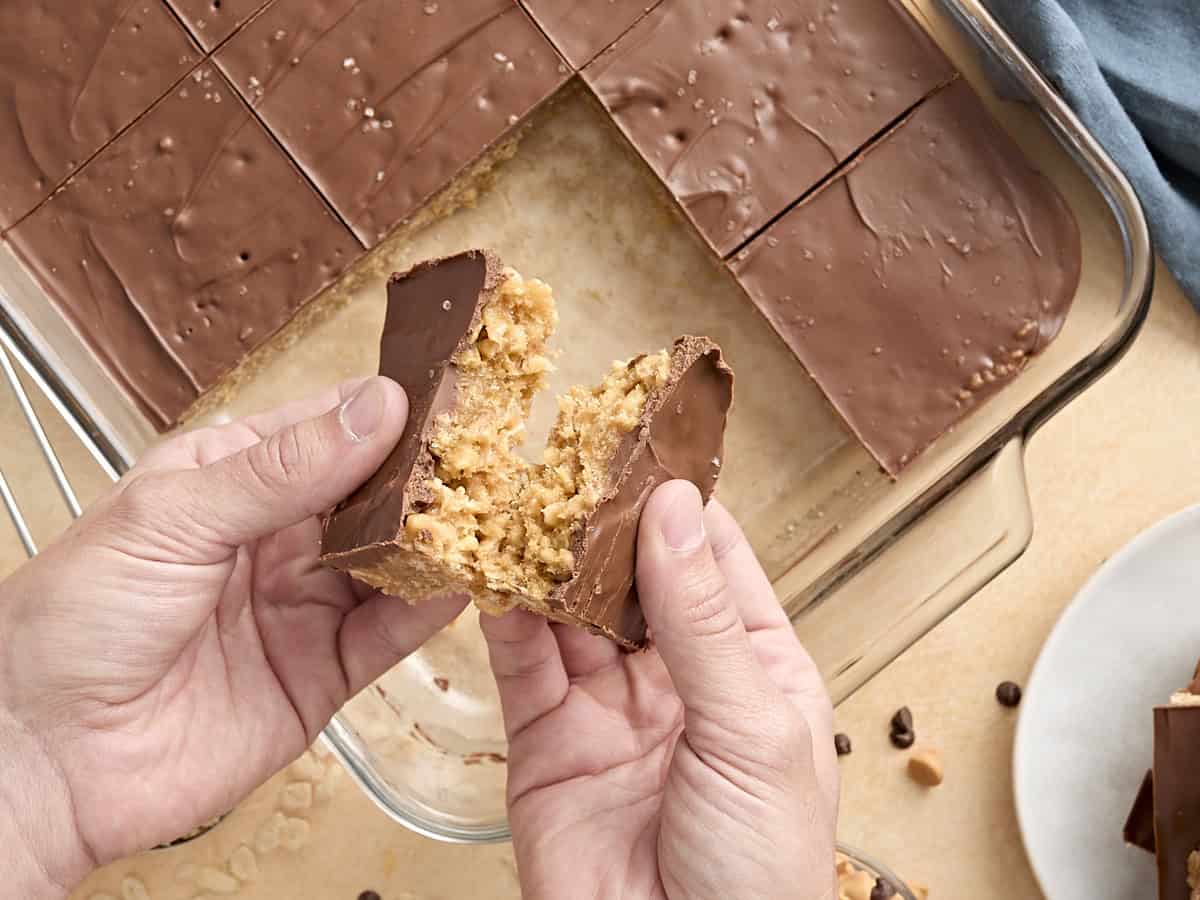 Des mains brisant un carré Scotcharoo en deux.