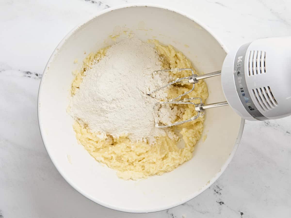 Farine ajoutée au mélange de beurre en crème et de sucre.