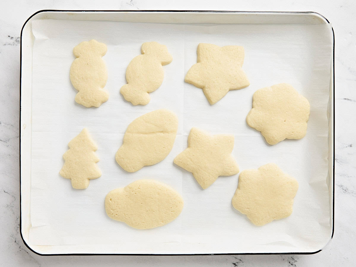 Biscuits au sucre cuits sur une plaque à pâtisserie tapissée de papier sulfurisé.