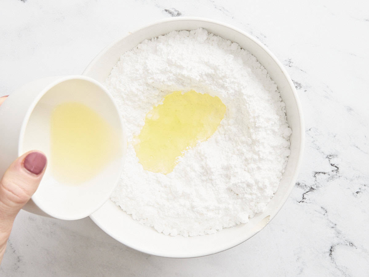 Blancs d'œufs ajoutés au sucre glace dans un bol.