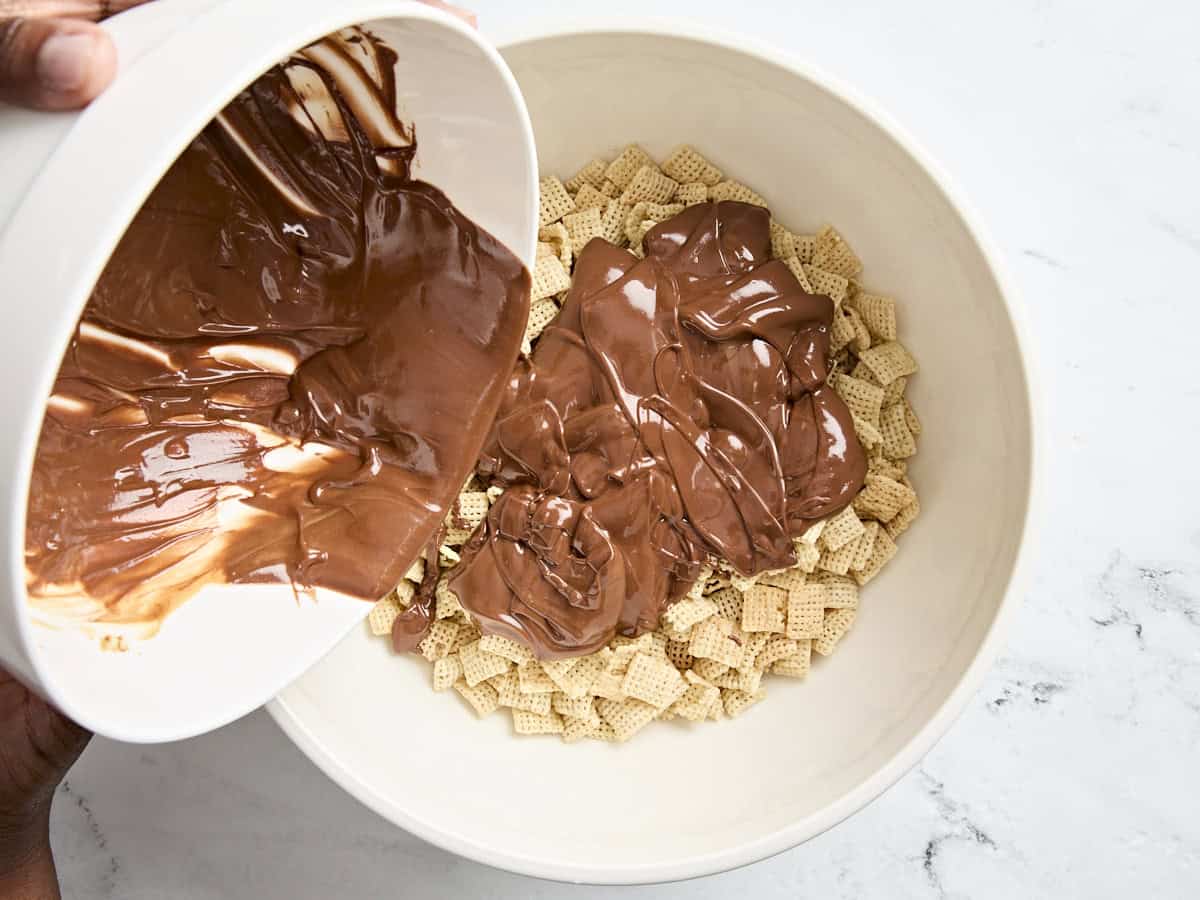 Du chocolat fondu et du beurre de cacahuète ajoutés à un bol de céréales de riz chex.