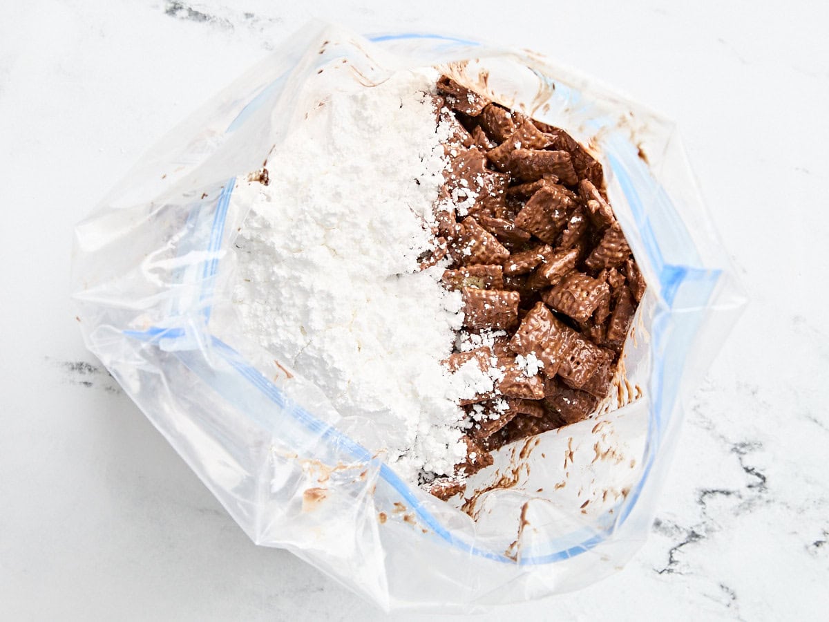 Céréales chex de riz enrobées de chocolat dans un sac avec du sucre en poudre.