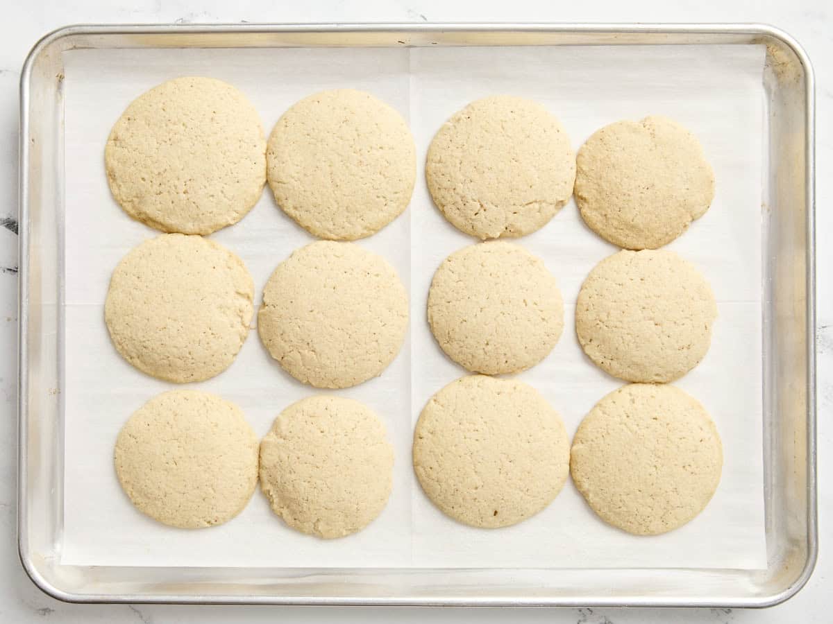 Biscuits au lait de poule cuits au four sur une plaque à pâtisserie tapissée de papier sulfurisé.