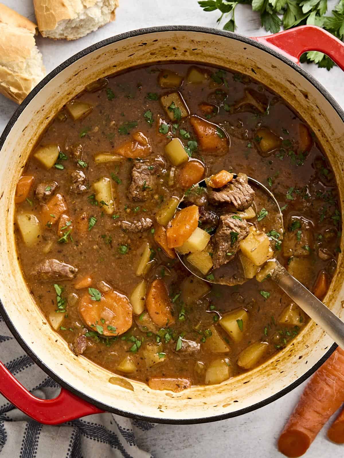 Vue aérienne du ragoût de bœuf dans une cocotte avec une louche.
